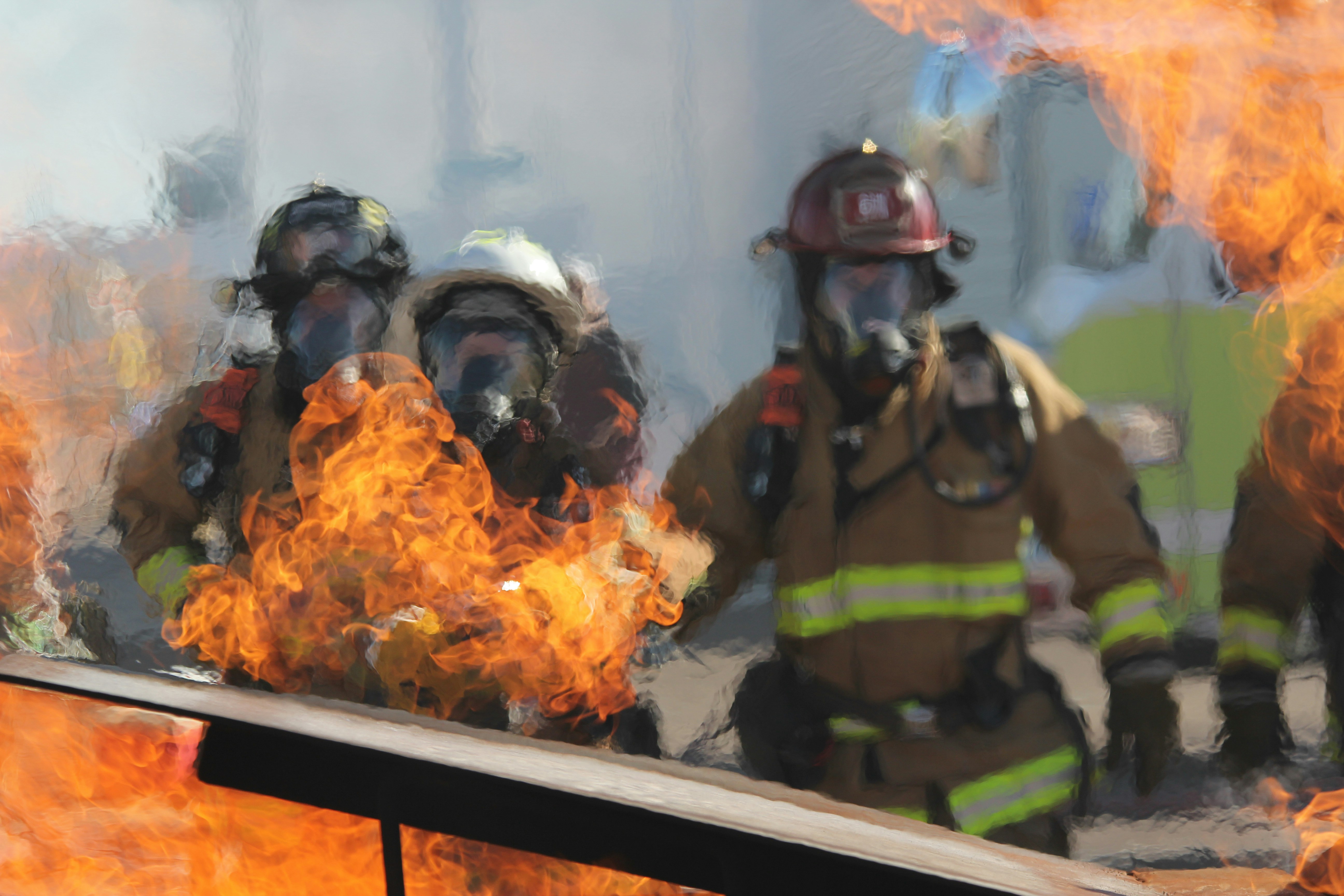 Firefighters in protective gear battling a blaze with intense flames
