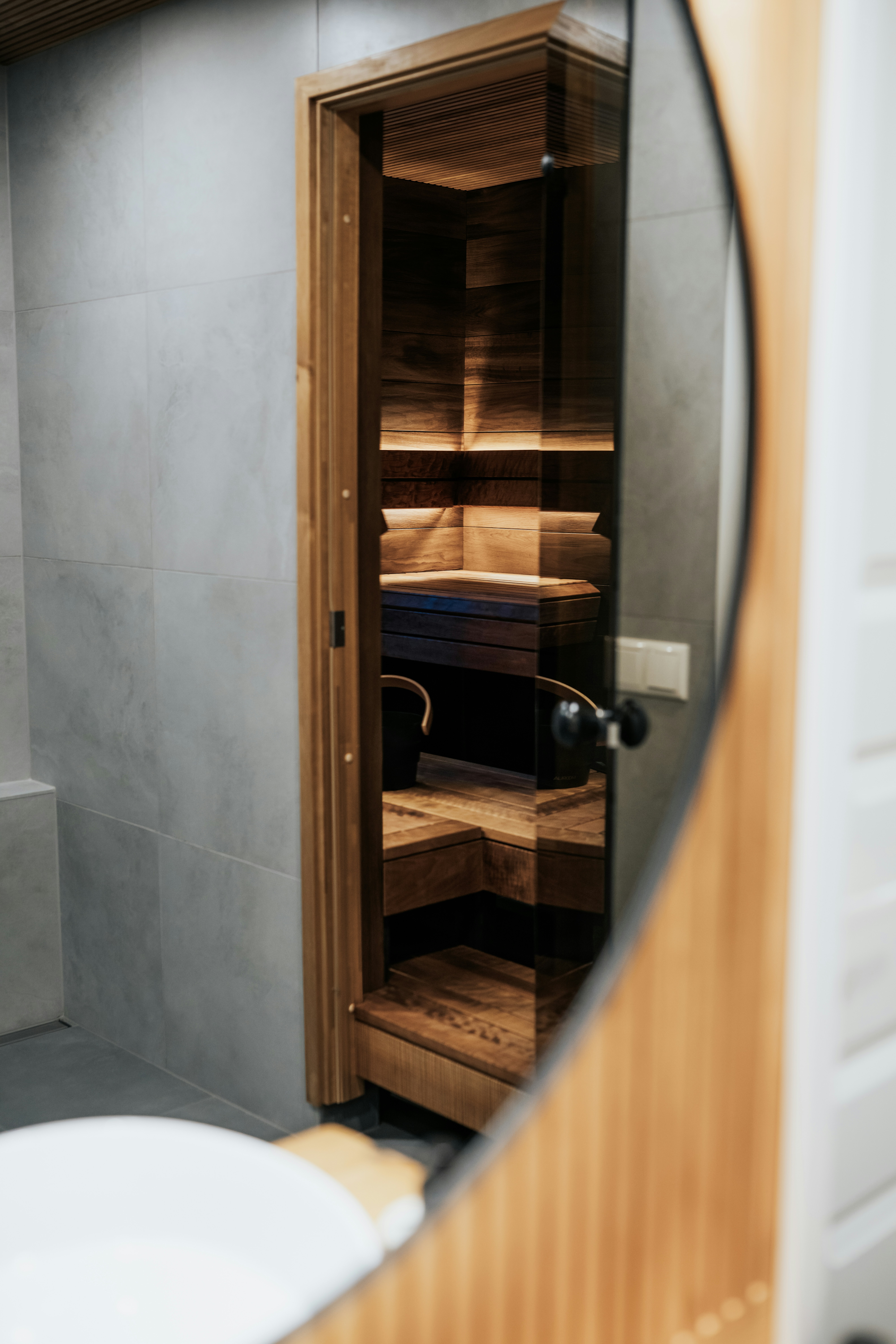 Modern sauna room with wooden interior viewed through a mirror