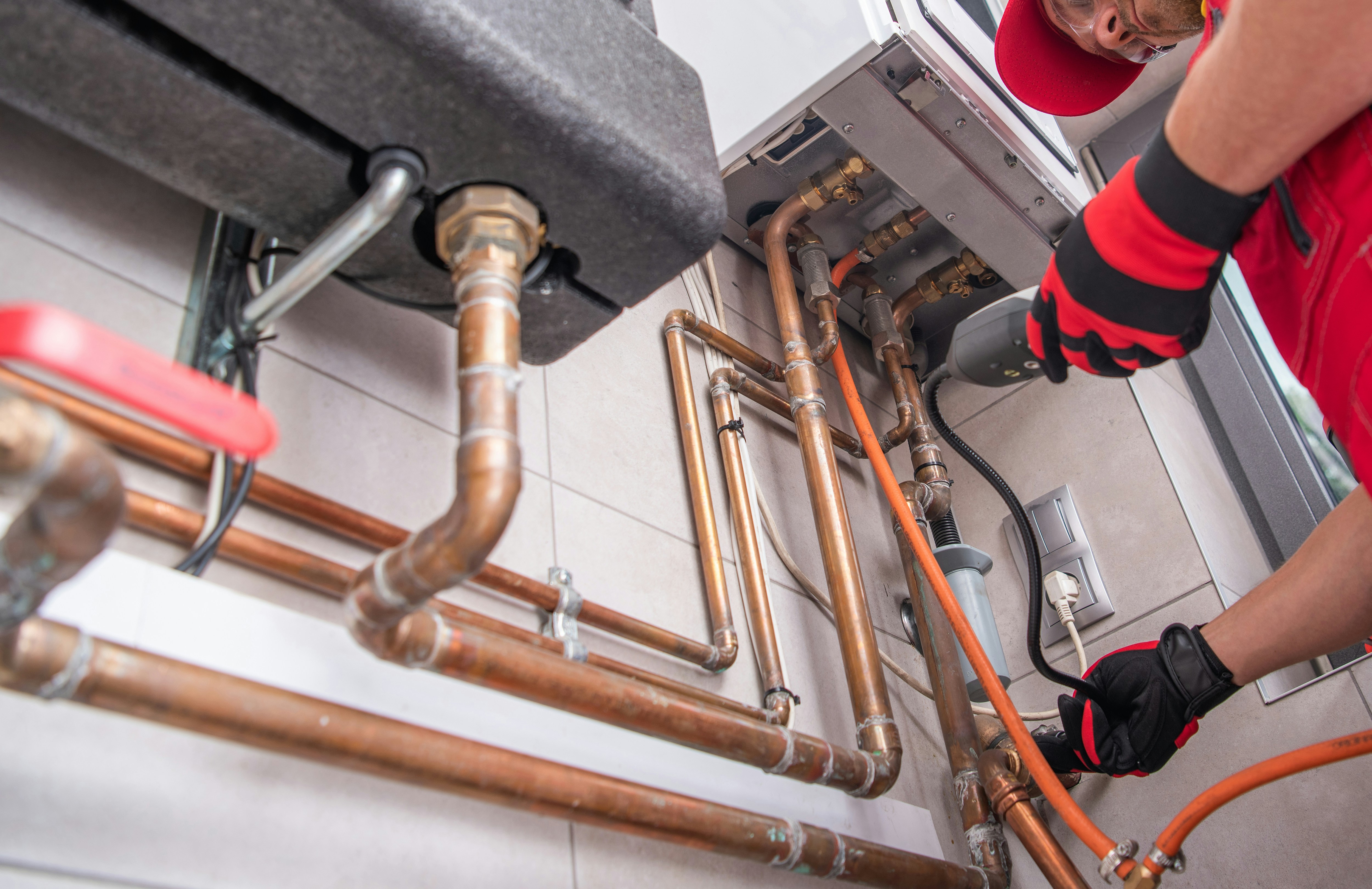 Plumber working on copper pipes in a building