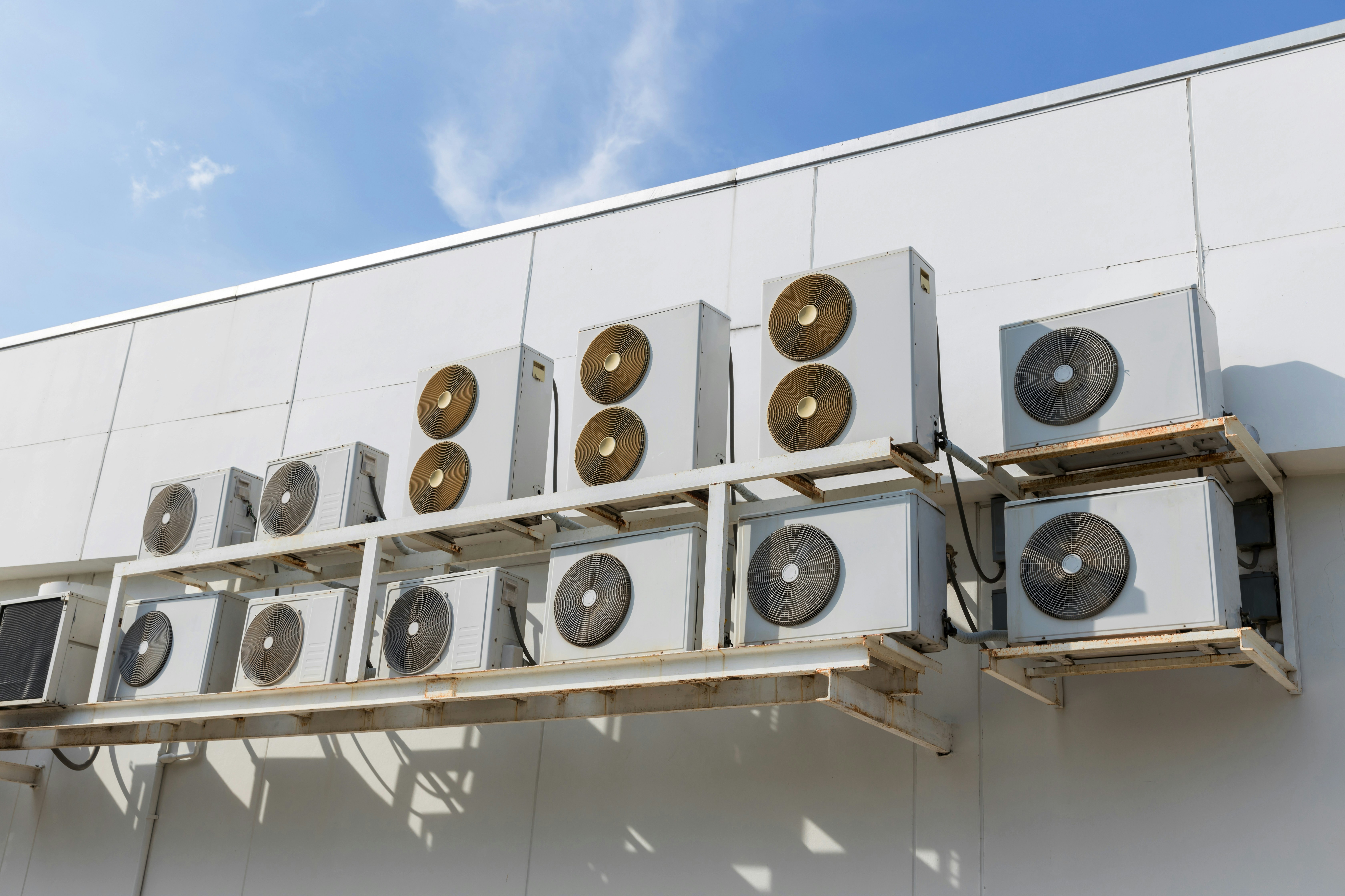 Multiple HVAC units installed on the exterior wall of a building.