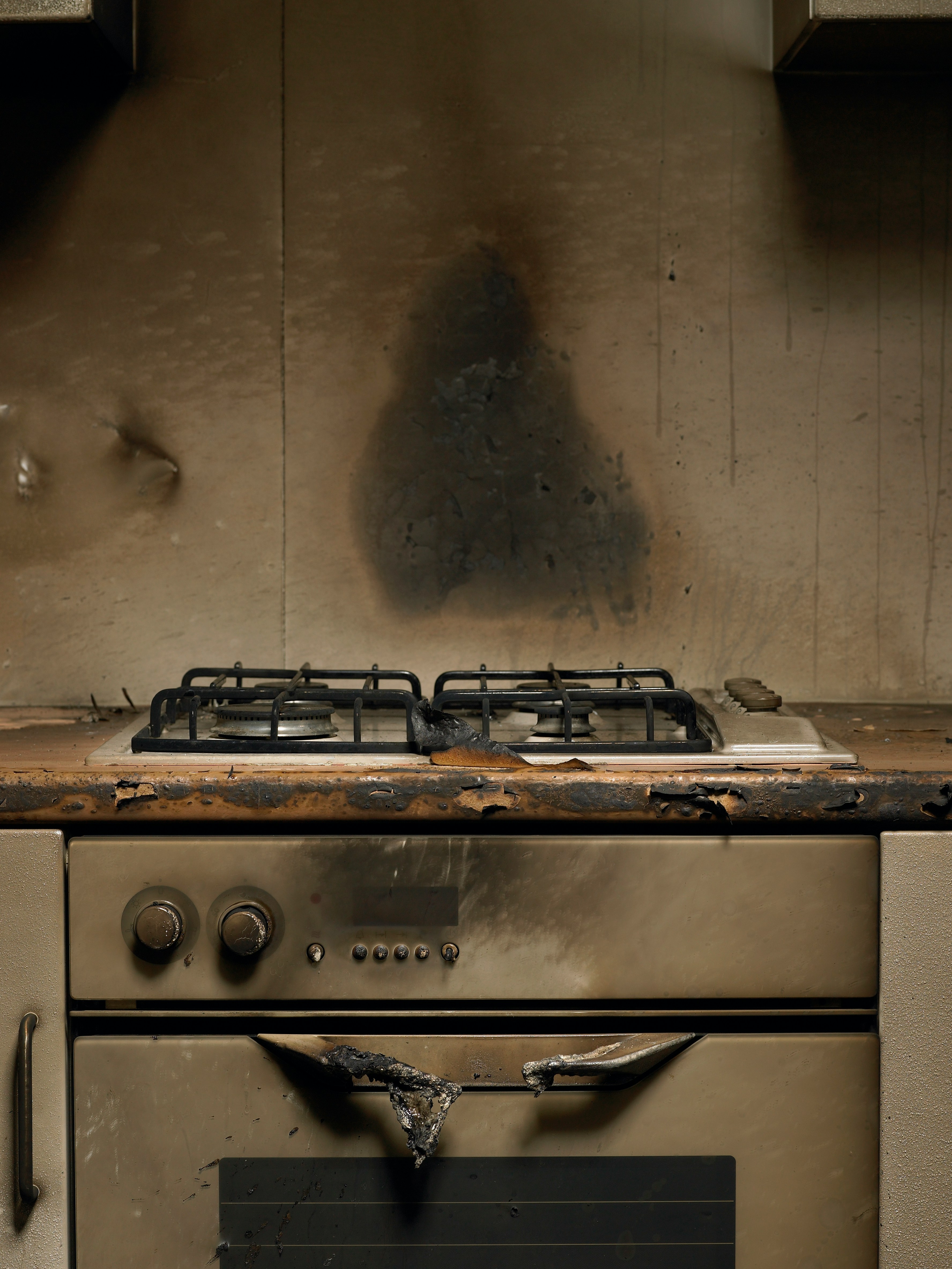 Damaged kitchen stove and oven with burn marks and soot
