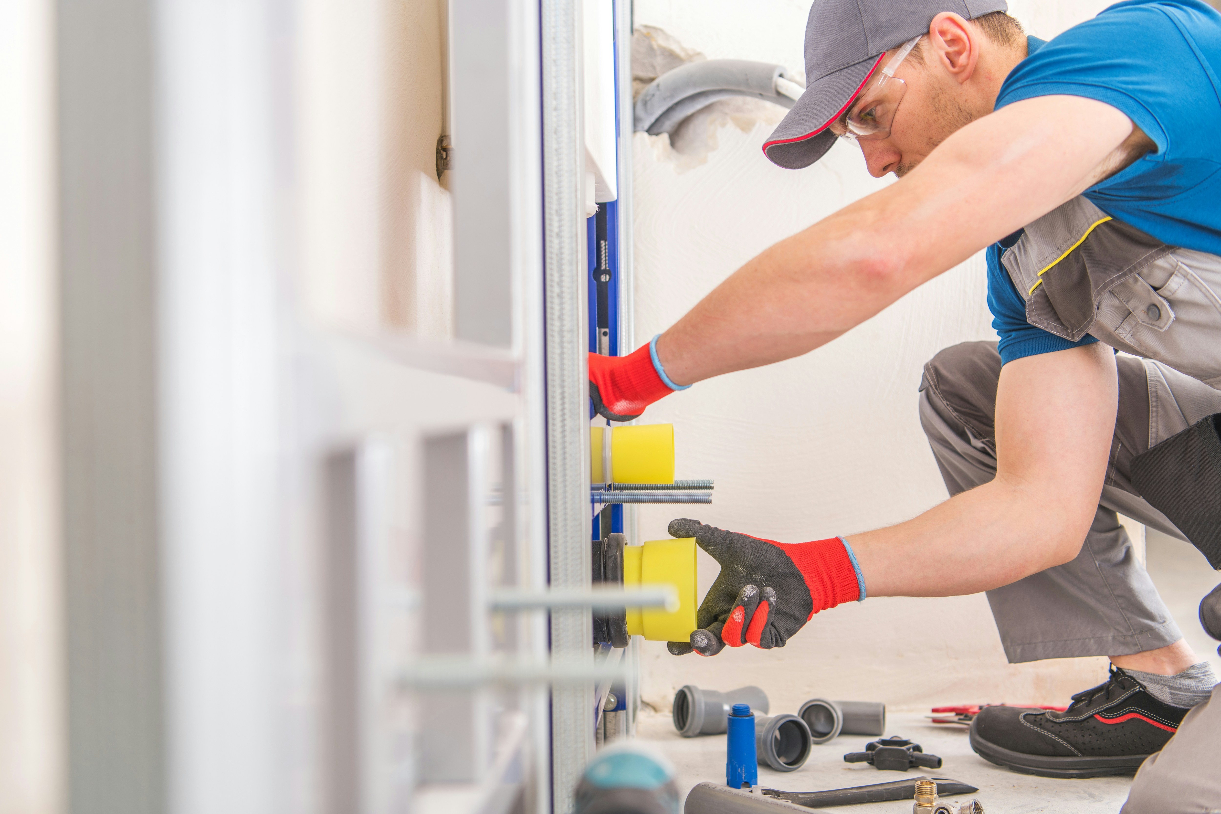 Construction worker installing plumbing fixtures in a bathroom.